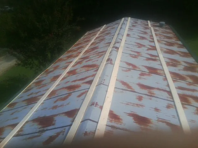 Rusted metal roof panels with new wood purlins before replacement — Storm Damage Roof Repair in Midland by Roofing Brothers